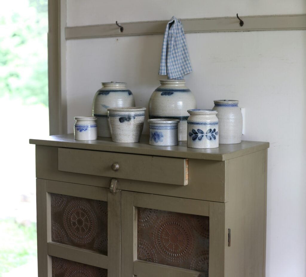 a group of white and blue pots on a cabinet